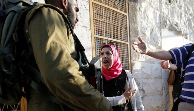 A Palestinian woman agues with an Israeli soldier near the scene of a stabbing attack in Hebron on Friday.