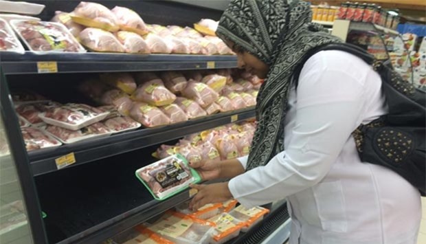 An official inspects chilled poultry products at an outlet.