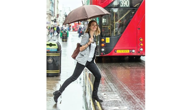 A woman braves the wet weather in Oxford Street yesterday.