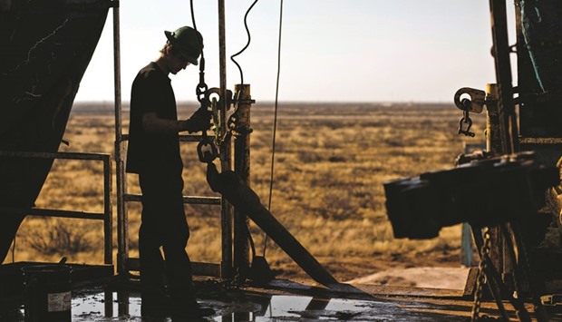 A worker waits to connect a drill bit on a rig in the Permian basin outside of Midland, Texas, US (file). Rigs targeting crude in the US rose by 2 to 416, extending the biggest reboot since crude prices first began falling two years ago.