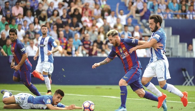 Barcelonau2019s Lionel Messi (second right) vies for the ball with Unai Lopez of Leganes during the Spanish league match at the Butarque municipal stadium in Leganes, Spain yesterday. (AFP)