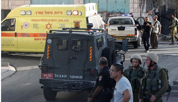 Israeli security forces gather at the scene of a reported Palestinian stabbing attack on an Israeli soldier near the Jewish settler enclave of Tal Rumeda in the city centre of the West Bank town of Hebron yesterday