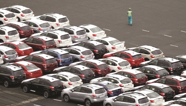 A worker walks beside newly-produced cars at Keihin industrial zone in Kawasaki, Japan. The country has more than a demand-side problem. Data on output per hour worked suggest a supply-side problem, most clearly manifested in the service sector, where the impressive ingenuity seen in so many manufacturing industries typically is nowhere in evidence.