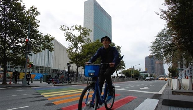 A man on a bike passes by United Nations headquarters in New York on Sunday.