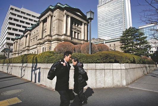 Pedestrians walk past the Bank of Japan headquarters in Tokyo. Speculation that the Japanese central bank is about to undertake a shift in monetary policy is changing the shape of bond markets around the globe.