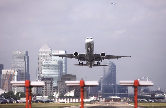 A passenger aircraft takes off from London City Airport against a backdrop of Canary Wharf business, financial and shopping district in London on May 26, 2016. Executives are reaching out to governments abroad to ask them to lobby EU policy makers on the importance of London maintaining unfettered access to the bloc.