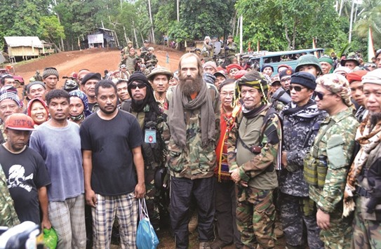 Moro National Liberation Front (MNLF) chairman Nur Misuari (fourth right) poses for photos with freed Norwegian national Kjartan Sekkingstad (centre), and three Indonesians (front left to right) during their turn-over ceremony in Indanan town, Sulu province, in southern island of Mindanao yesterday.