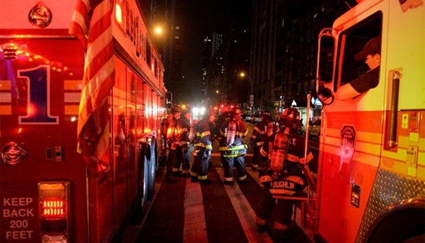 New York City firefighters stand near the site of an explosion in the Chelsea neighborhood of Manhattan, New York, US