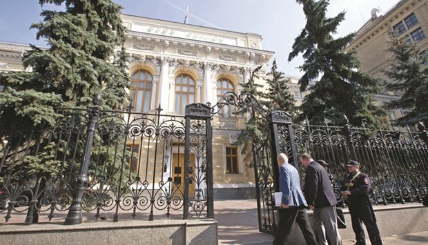 Visitors pass security to enter the headquarters of Russiau2019s central bank in Moscow. While the Bank of Russiau2019s hawkish rates message on Friday sent a chill across fixed-income desks, investors from Oppenheimer Holdings to Aberdeen Asset Management see a buying opportunity.