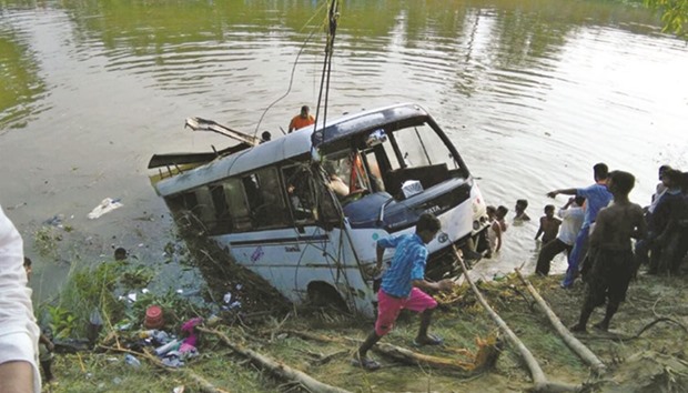 Rescue workers pull out the bus from a pond yesterday.
