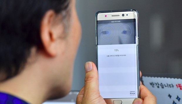 A South Korean man sets up iris recognition function on his replacement Samsung Galaxy Note7 smartphone at a telecommunications shop in Seoul.
