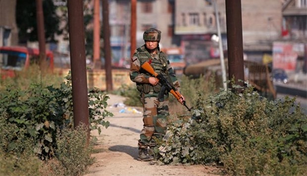 An Indian army soldier stands guard alongside a street on the outskirts of Srinagar on Tuesday.