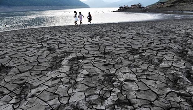 A file photo shows people walking along the dried and cracked river beach of the Yangtze River in Yunyang county in Chongqing, China.