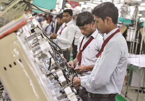 Employees work on a car wiring assembly line inside a factory in Noida on the outskirts of New Delhi. According to Moodyu2019s, some measures if effectively implemented can push Indiau2019s growth, notably an easing of restrictions on FDI to foster productivity, bankruptcy law for enhancing investor confidence and measures aimed at ease of doing business.