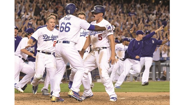 Los Angeles Dodgers shortstop Corey Seager (No 5) celebrates with right fielder Yasiel Puig (No 66) after scoring in the ninth inning on a walk-off double by first baseman Adrian Gonzalez (not pictured) during a 2-1 victory over the San Francisco Giants in an MLB game at Dodger Stadium in Los Angeles. 