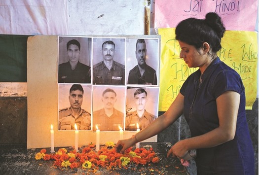 A woman lights candles during a vigil for the soldiers who were killed in Sundayu2019s attack at an army base in Uri, at a school in Jammu, yesterday.