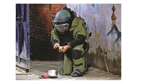 A member of the bomb disposal team checks an improvised explosive device after detonating it outside a school in Kathmandu yesterday.