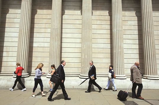 Pedestrians walk past the Bank of England building in the City of London. The BoE will cut interest rates close to zero later this year as concern persists about the longer-term impact of the Brexit vote, according to a survey.