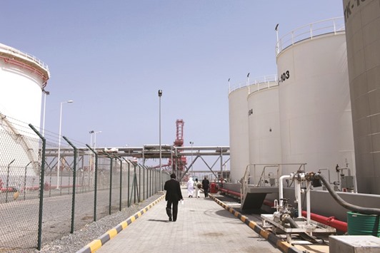 Visitors walk past oil containers inside Fujairah port in Fujairah, UAE (file). Fujairah plans to boost its influence as an oil-trading hub with the addition of the regionu2019s first crude-shipment jetty and expanded storage facilities.