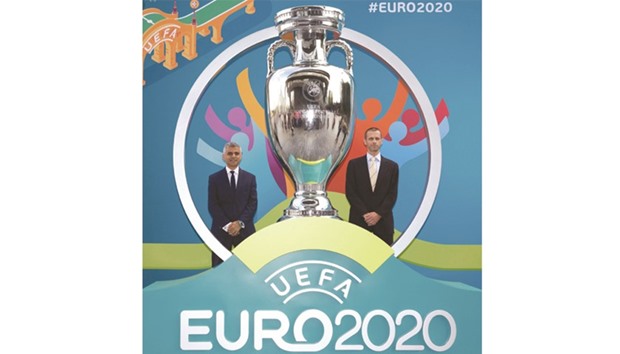 London mayor Sadiq Khan (left) and UEFA president Aleksander Ceferin pose for photographers with a replica cup at an event to launch the logo for the 2020 UEFA European Championship in London yesterday. The 2020 edition of the tournament will see matches hosted in 13 cities across Europe, with the semifinals and final at Wembley Stadium in London. (AFP)