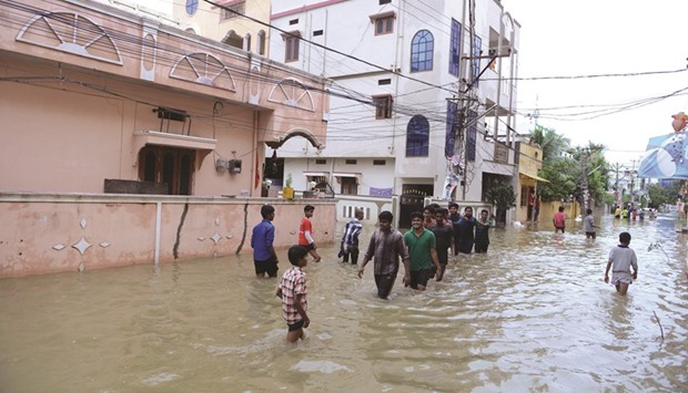 Residents make their way through floodwaters following heavy rain in Nizampet, a low lying area on the outskirts of Hyderabad yesterday. The India Meteorology Department (IMD) has alerted people and the state governments of Telangana and Andhra Pradesh about heavy rains.