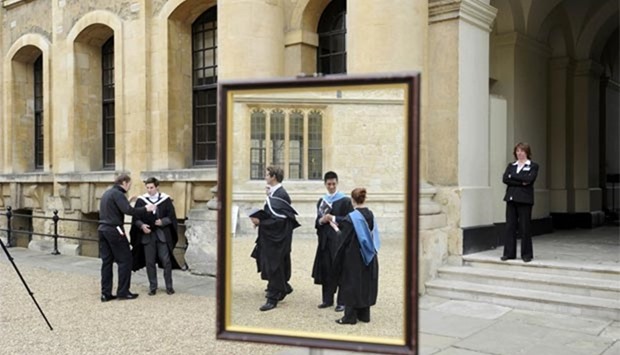Graduates queue to have their photograph taken after a graduation ceremony at Oxford University in this file photo.