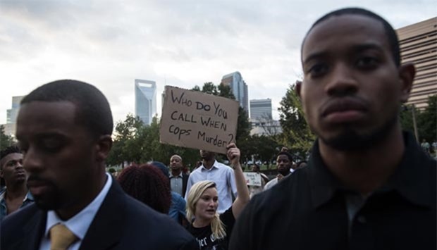 Protesters hold up signs during a demonstration against police brutality in Charlotte, North Carolina, on Wednesday, following the shooting of Keith Lamont Scott the previous day.