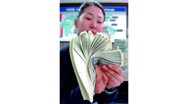 A Korea Exchange Bank clerk checks US hundred dollar bills at its headquarters in Seoul (file). For dollar bulls, the disappointments keep adding up. At the start of the year, the consensus was for the US currency to strengthen to $1.05 per euro and u00a5125 by year-end. Instead, it has weakened more than 3% to $1.1239 per euro and 16% to u00a5100.80, forcing analysts to cut their forecasts to keep pace.