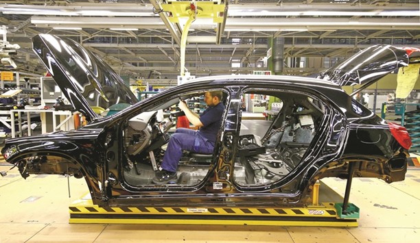 An employee of Mercedes Benz works on the interior of a GLA model at their production line at the factory in Rastatt. German economic growth was robust in the first half of the year, the Finance Ministry said in its monthly report. But the latest economic data indicate a slowdown in economic momentum in the second half of the year.
