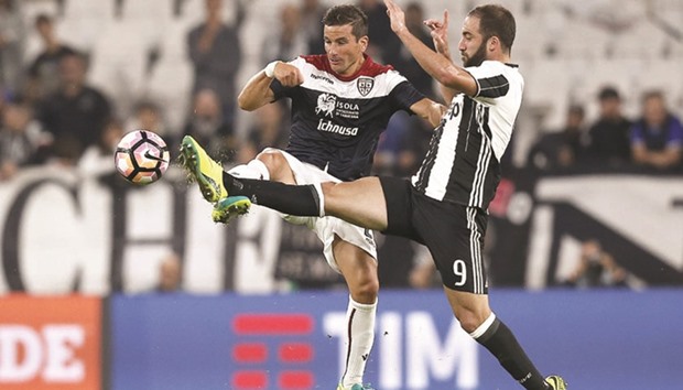 Cagliariu2019s Simone Padoin (left) and Juventusu2019 Gonzalo Higuain battle for the ball in Turin on Wednesday night. (AFP)