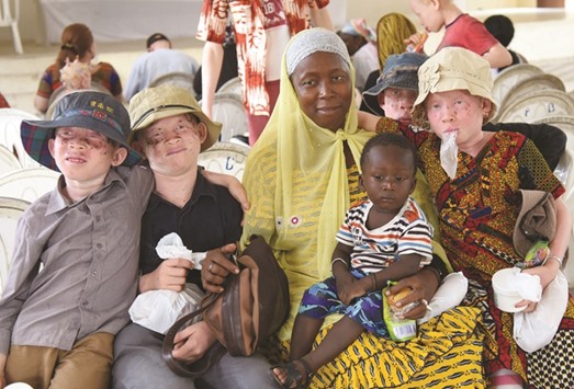 Albino children pose with a woman and a child during a sunglasses and sunblock distribution in Abidjan, Ivory Coast, on Wednesday.