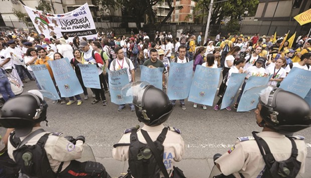 Venezuelan police in riot gear face demonstrators before an opposition march in Caracas on Thursday.