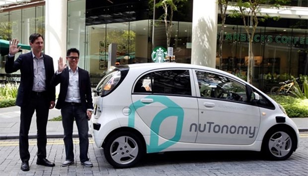 CEO of nuTonomy Karl Iagnemma (left) and Grab's Head of Singapore Lim Kell Jay pose next to a driverless car in Singapore on Friday.