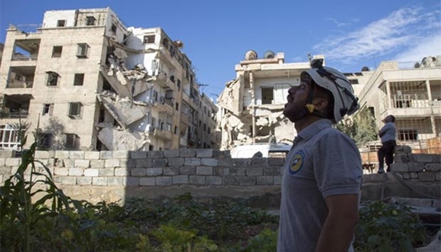 A Syrian rescuer looks towards the sky following an air strike in the rebel-held Ansari district in Aleppo on Friday.