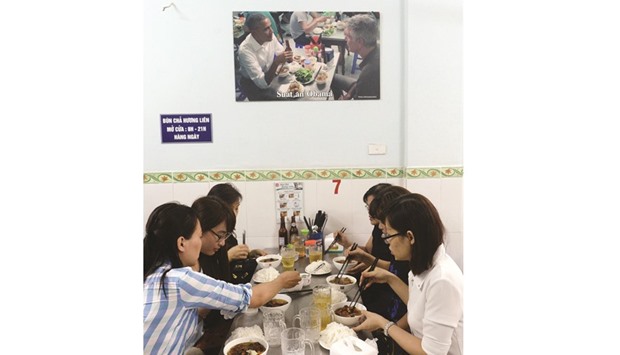 This picture taken on September 12 shows patrons eating under a picture showing US President Barack Obama during his visit to the same Bun Cha Huong Lien restaurant in May.