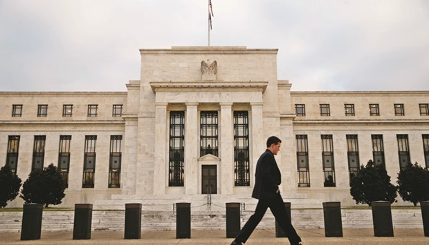 A man walks past the Federal Reserve building in Washington, DC. While the Fed doesnu2019t have the power to sever banksu2019 ties to physical commodities, it is seeking massive capital increases for the activities, especially at Goldman Sachs and Morgan Stanley, which have special legal exemptions to stay in those businesses.
