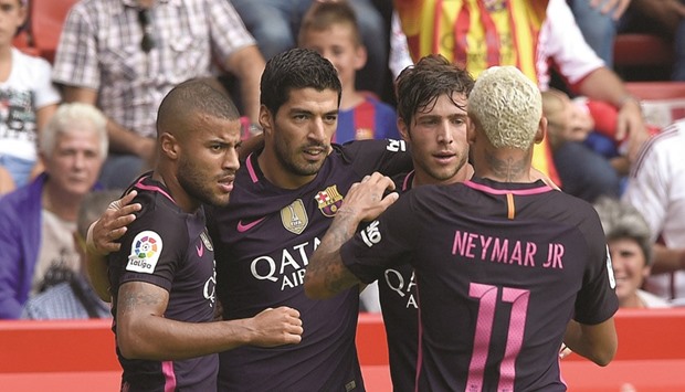 Barcelona striker Luis Suarez (second from left) celebrates with teammates after scoring the opening goal against Sporting Gijon goal yesterday. (Reuters)