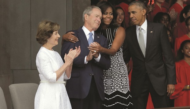 First Lady Michelle Obama hugs former president George W Bush as President Barack Obama and former first lady Laura Bush look on at the Smithsonianu2019s National Museum of African American History and Culture in Washington.