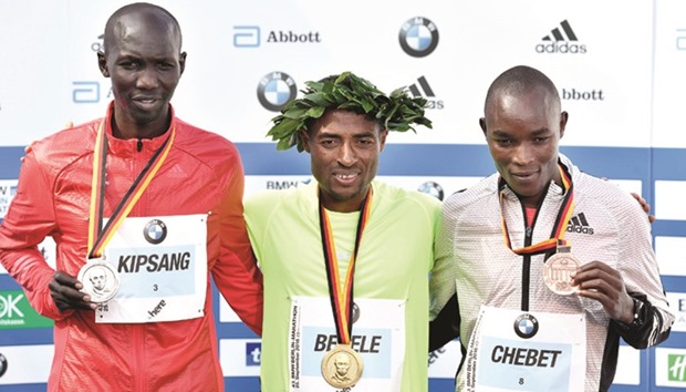 (From L) Kenyau2019s Wilson Kipsang (2nd placed), Ethyopiau2019s Kenenisa Bekele (winner) and Kenyau2019s Evans Chebet (third placed) pose on the podium with their medals after the 43rd Berlin Marathon in Berlin yesterday. (AFP)