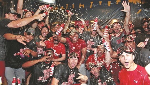 The Washington Nationals celebrate in the clubhouse after clinching the National League Eastern Division Championship by defeating the Pittsburgh Pirates in Los Angeles on Saturday. The  Nationals won 6-1.