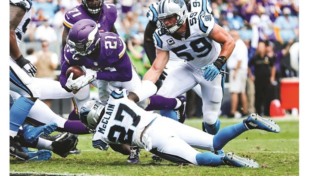 Minnesota Vikings running back Jerick McKinnon (left) dives in for a touchdown over Carolina Panthers defensive back Robert McClain and middle linebacker Luke Kuechly (right) during the second half of the NFL game in Charlotte. (USA TODAY Sports)