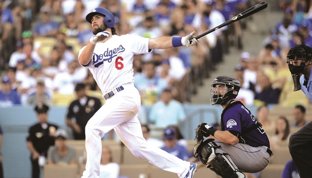 Los Angeles Dodgers shortstop Charlie Culberson (left) hits a walk off solo home run during the tenth innings against the Colorado Rockies at Dodger Stadium in Los Angeles. With the victory, the Dodgers clinched the National League West title on Sunday. (USA TODAY Sports)