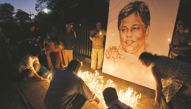 Activists and members of civil societies light candles in front of a portrait of Lasantha Wickrematunge in a silent vigil condemning his killing in Colombo.