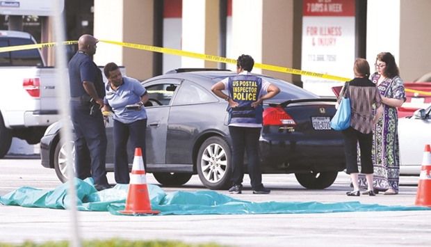 Investigators looks over the scene where nine individuals were shot at a strip mall along Weslayan St in Houston, Texas.