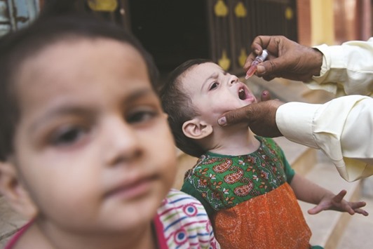 A health worker administers polio vaccine drops to a child during a door-to-door polio campaign in Karachi yesterday.