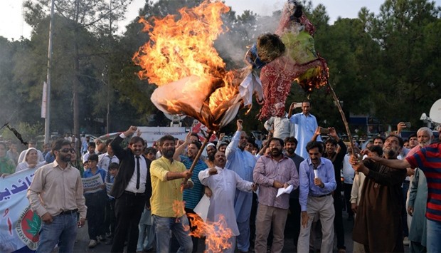 Pakistani Kashmiris burn effigies of Indian PM Narendra Modi and Foreign Minister Sushma Swaraj during a protest in Islamabad
