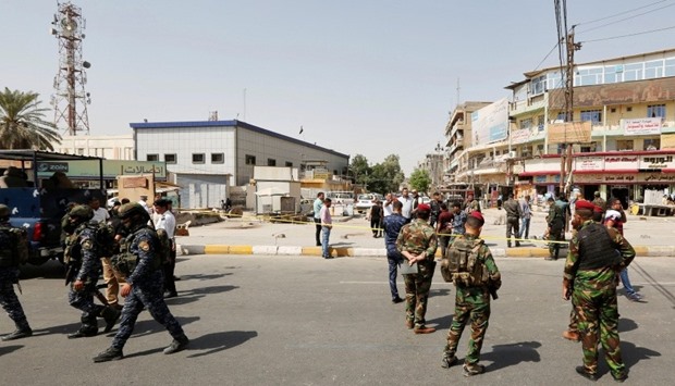 Iraqi security forces gather at the site of a suicide bomb blast in Baghdad