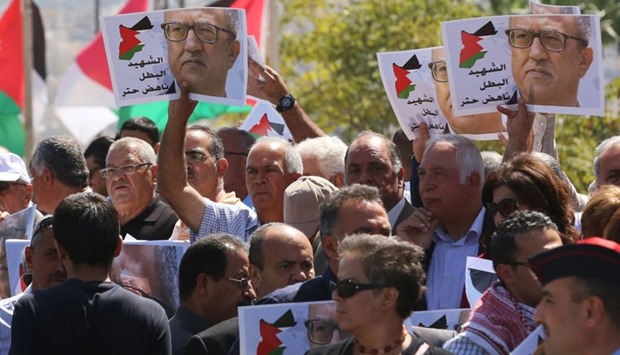 Protesters shout slogans and hold portraits of prominent Jordanian writer Nahed Hattar, who was shot dead the previous day outside an Amman court, during a demonstration in front of the prime minister's offices on September 26, 2016