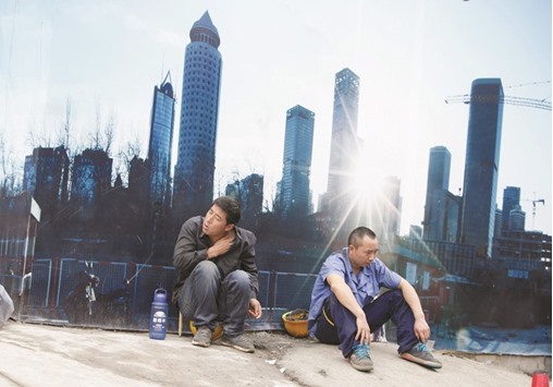 Workers rest outside a construction site in Beijingu2019s central business district. The Asian Development Bank yesterday increased its growth forecast this year for China to 6.6% from 6.5% and for 2017 to 6.4% from 6.3%, citing fiscal and monetary stimulus measures in the worldu2019s second-largest economy.