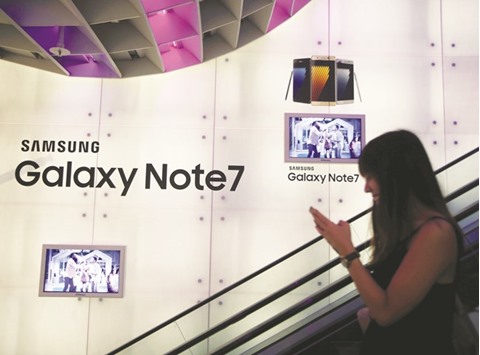 A woman passes a Samsung Note 7 advertisement in Singapore. The company has been engulfed in perhaps the worst crisis in its corporate history after Note 7 smartphones began to burst into flames just days after hitting the market in August.